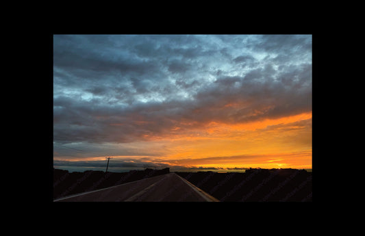 Fine art print of large clouds and sunset over road.  Print view