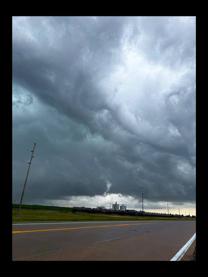 Fine art print of large storm clouds  building over a train and factory.  Print view