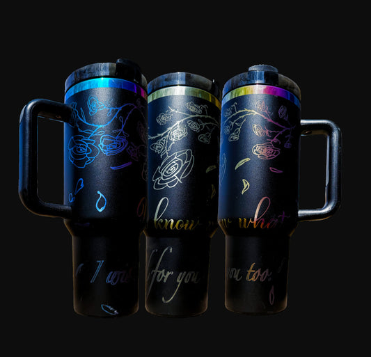 40oz iridescent black "The Spellbound" tumbler with laser engraved view of roses and rose petals falling over the words "You know what? I wished for you too" shown from three angles.