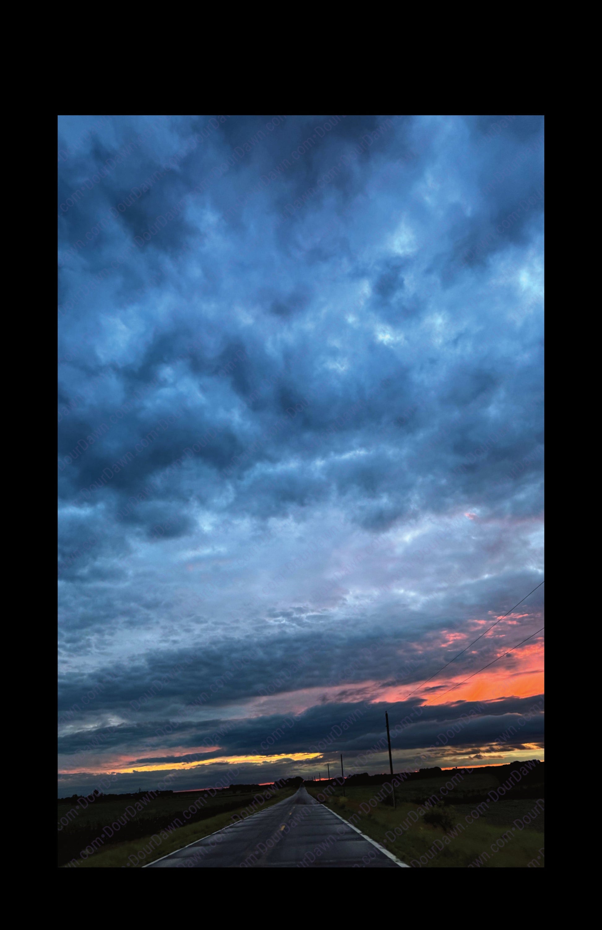 Fine art print of large clouds after a storm and sunset over rural road.  Print view